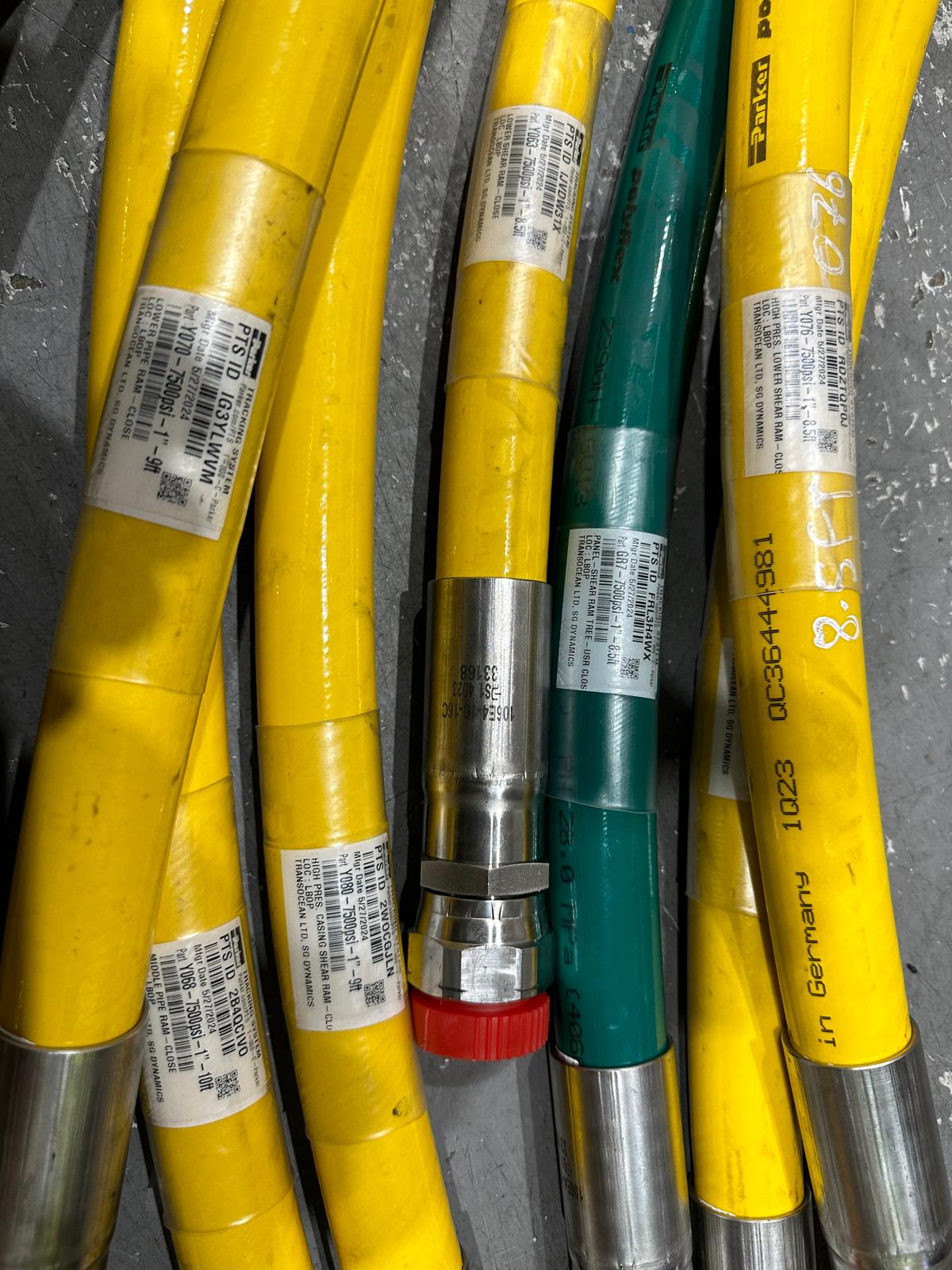 Close-up of green, yellow, and blue hoses with fittings, labeled and bundled for various industrial purposes.