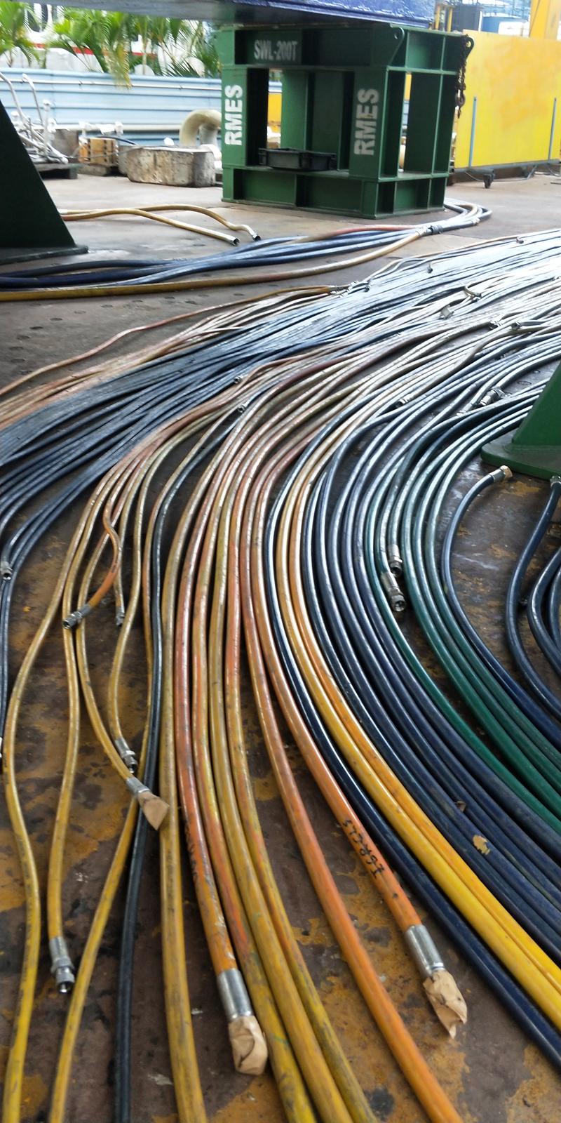 Color-coded hydraulic hoses organized on the floor, ready for installation or testing in an industrial or subsea system.
